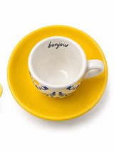 Top view of Bonjour espresso cup showing lettering inside the rim and bright yellow saucer