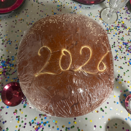 cake with '2026' on top, surrounded by confetti and red plates.